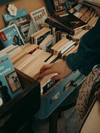 La main d'une femme sélectionnant délicatement un livre dans une collection de librairie vintage
